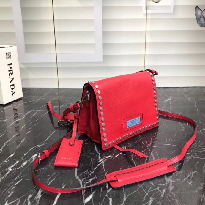 Pra*a etiquette bag in red calfskin with metal stud trim