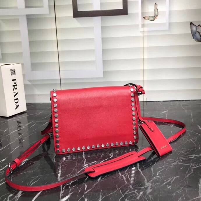 Pra*a etiquette bag in red calfskin with metal stud trim