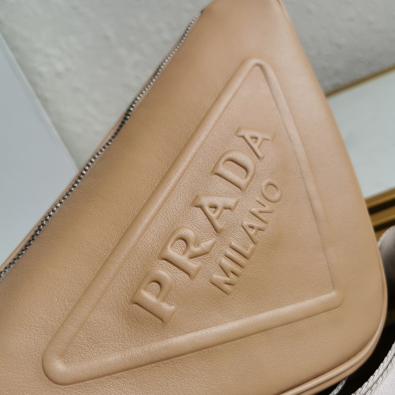 Pra*a triangle shoulder bag in beige leather