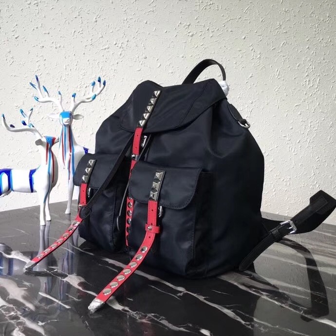 Pra*a black nylon backpack with red metal studs