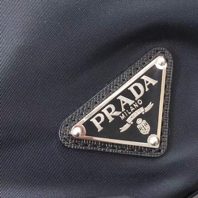 Pra*a black nylon backpack with red metal studs