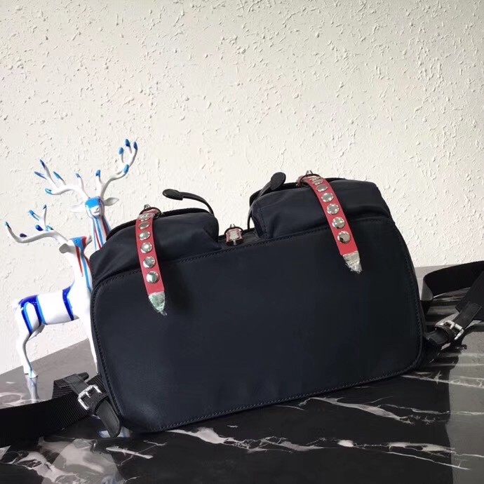 Pra*a black nylon backpack with red metal studs