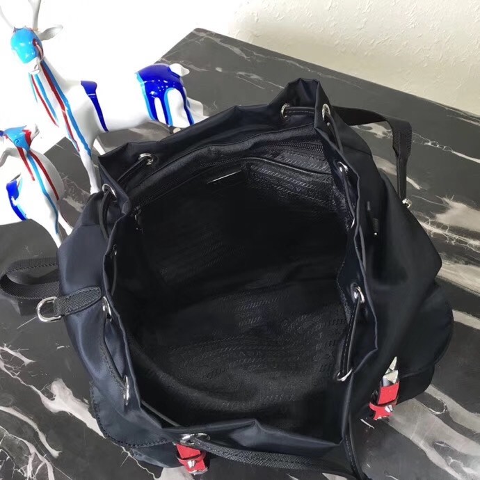 Pra*a black nylon backpack with red metal studs