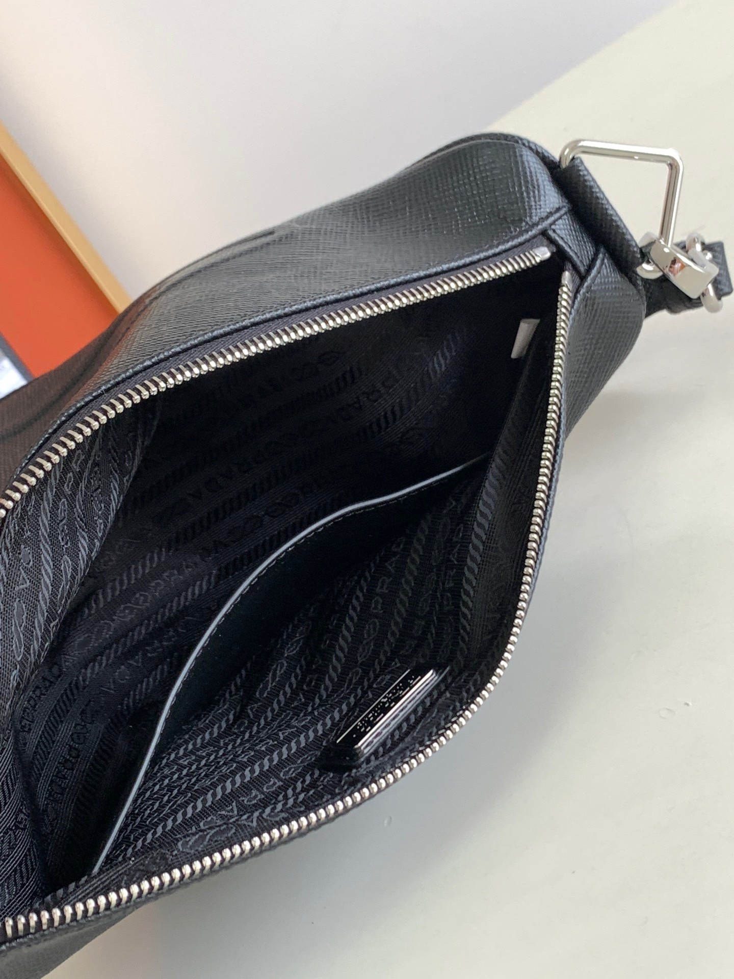 Pra*a triangle shoulder bag in black saffiano calfskin