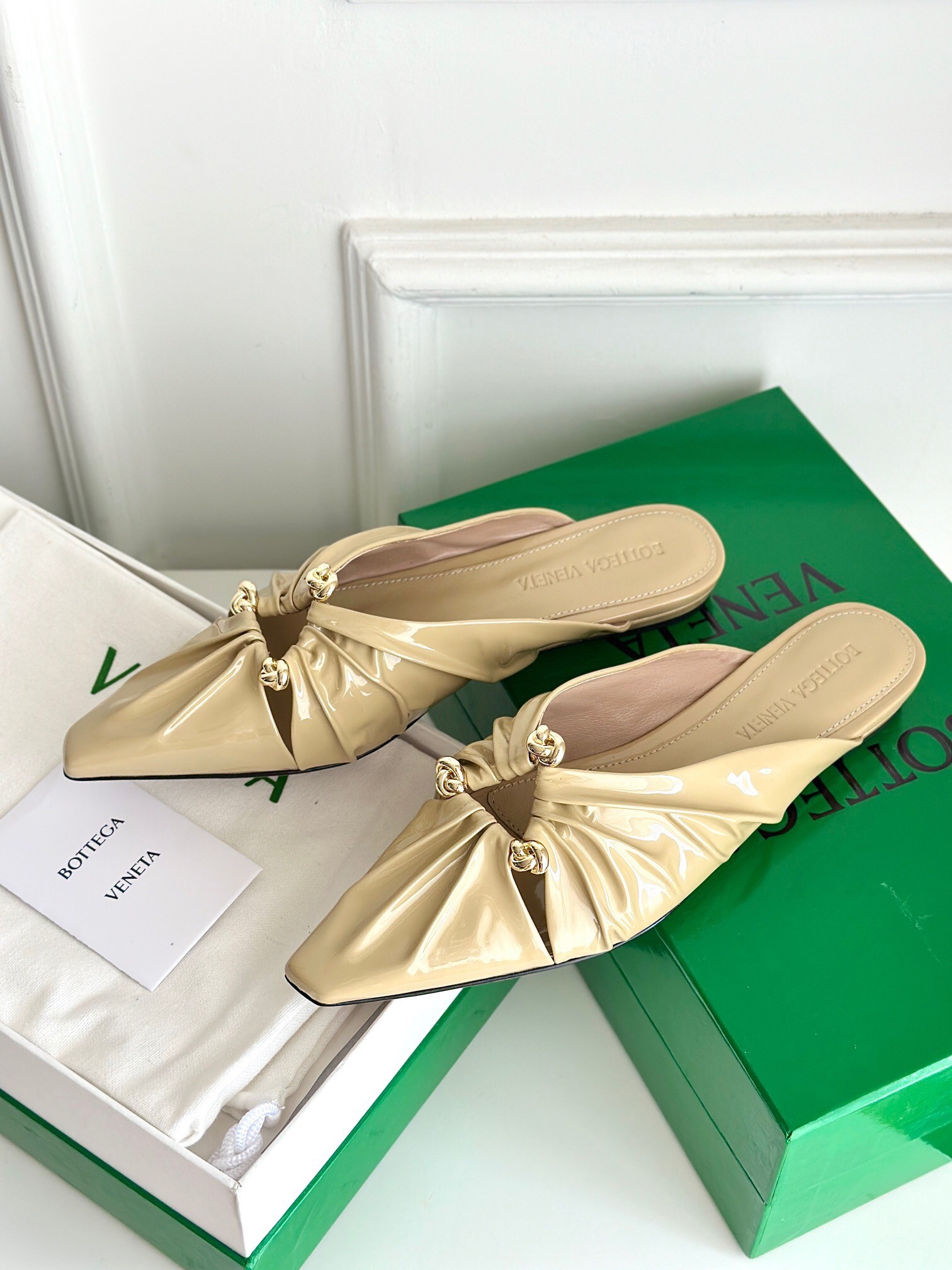 bo*te*ga Ve*ne*ta bunnie flat mules in beige patent leather