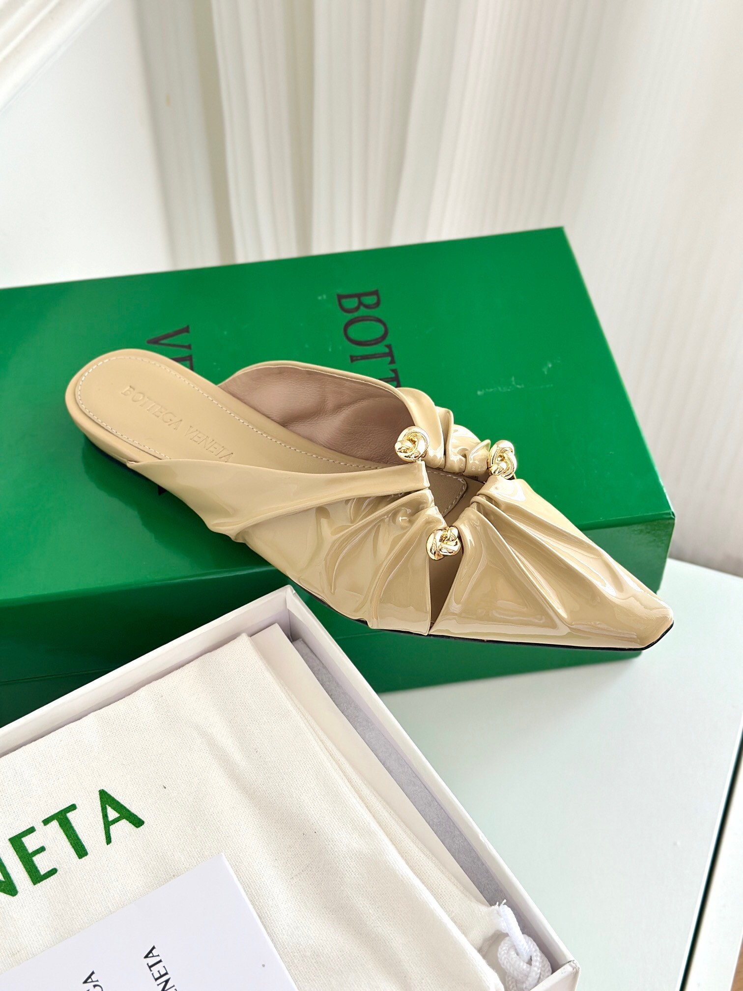 bo*te*ga Ve*ne*ta bunnie flat mules in beige patent leather